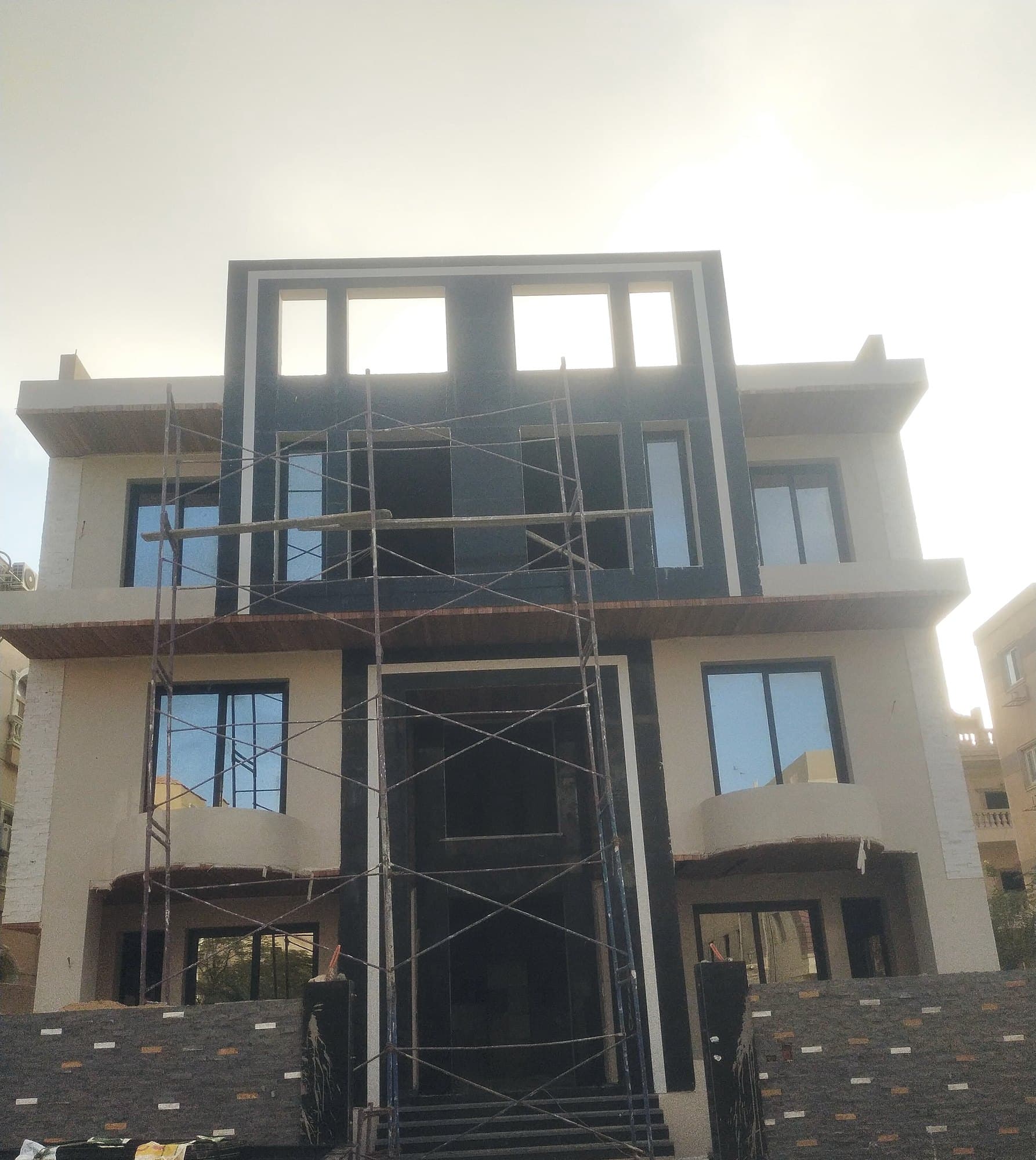 Residential building during construction with dark uPVC windows fitted