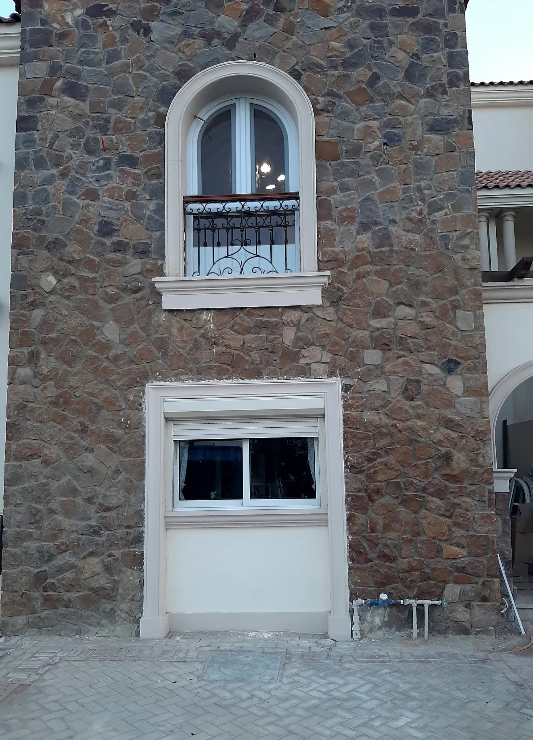 Arched window in a stone-clad tower, with a window below