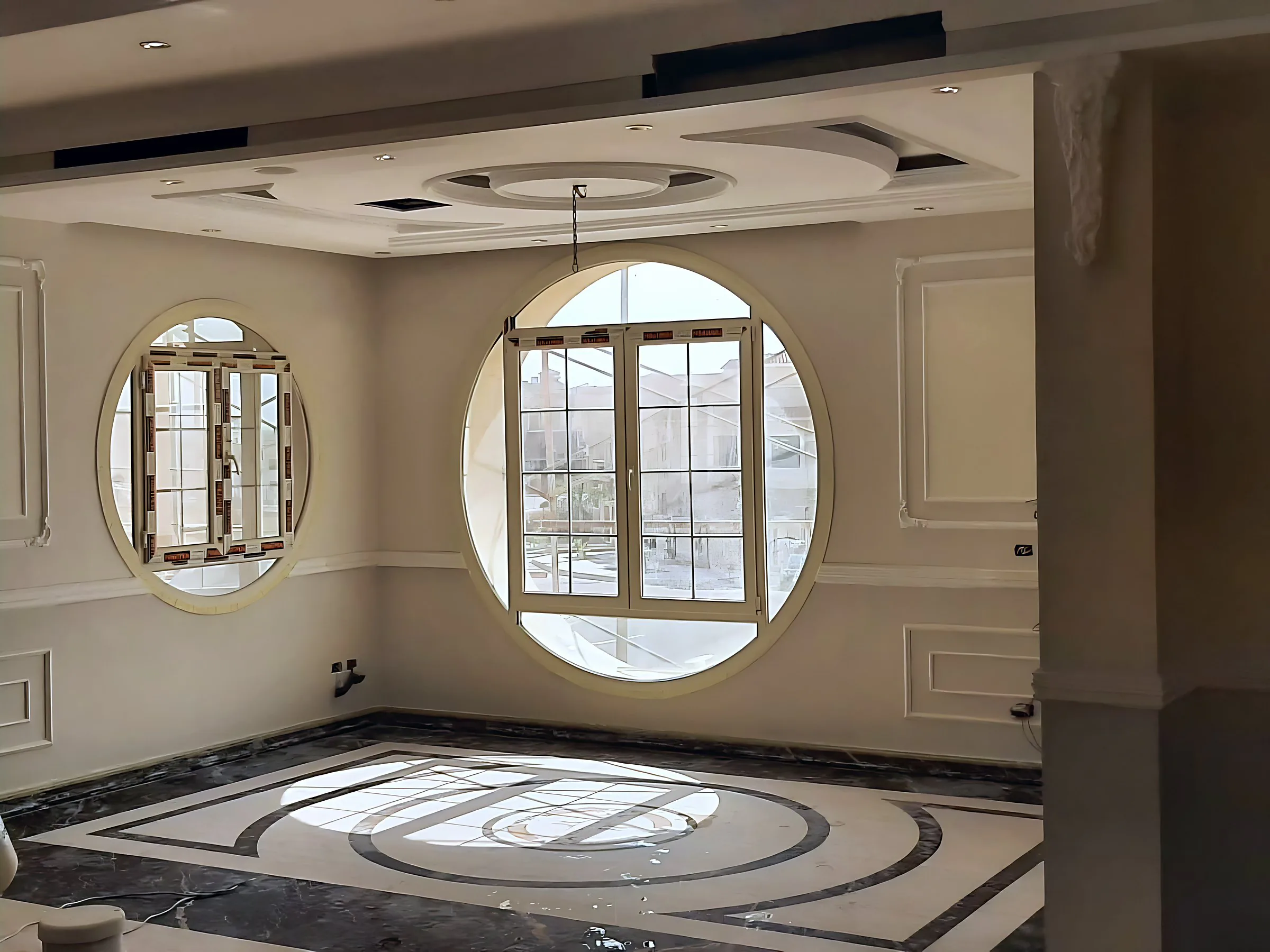 Reception room with two round windows and an inlaid marble floor
