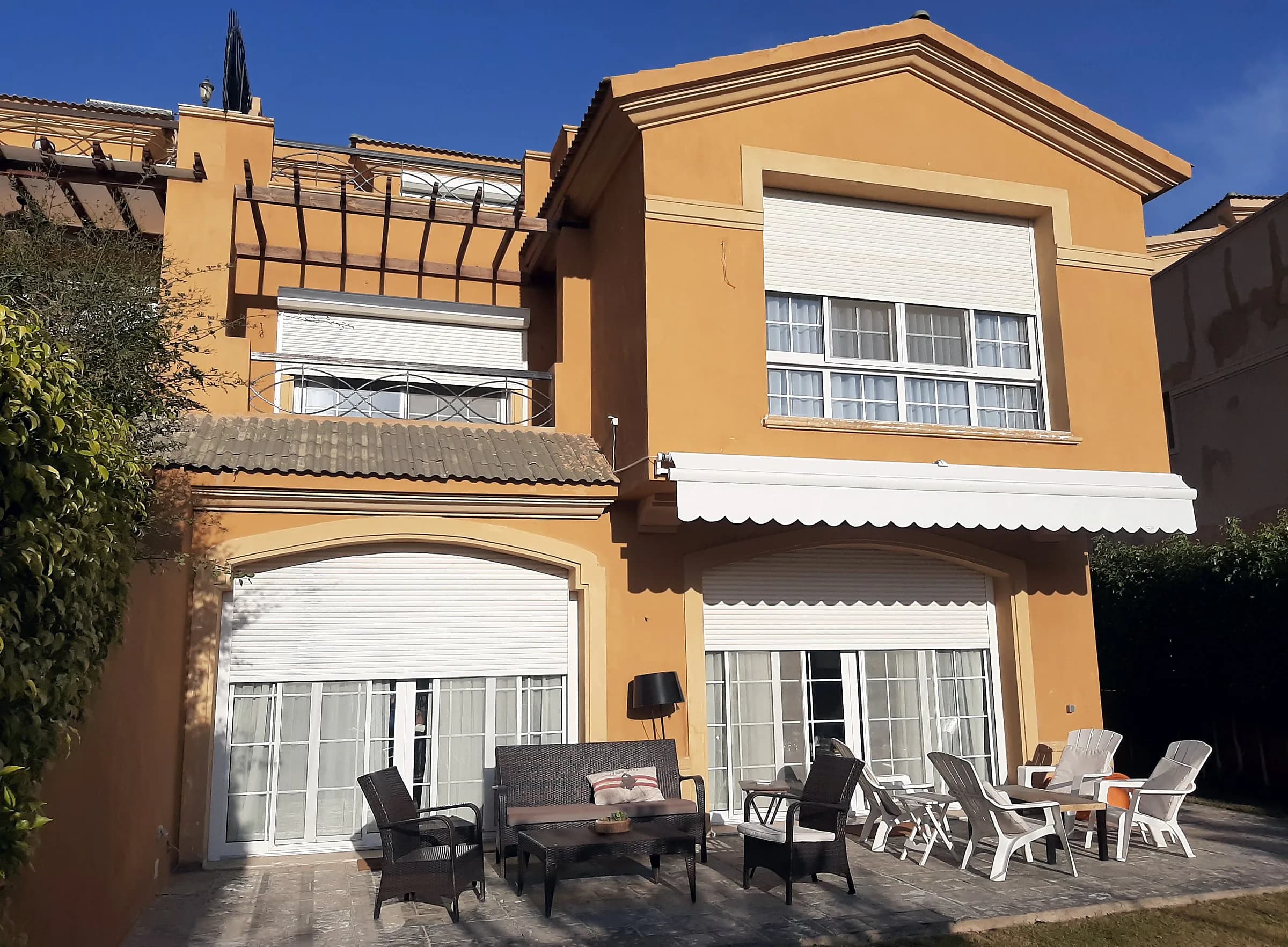 Villa terrace with roller shutters and an awning over the garden doors