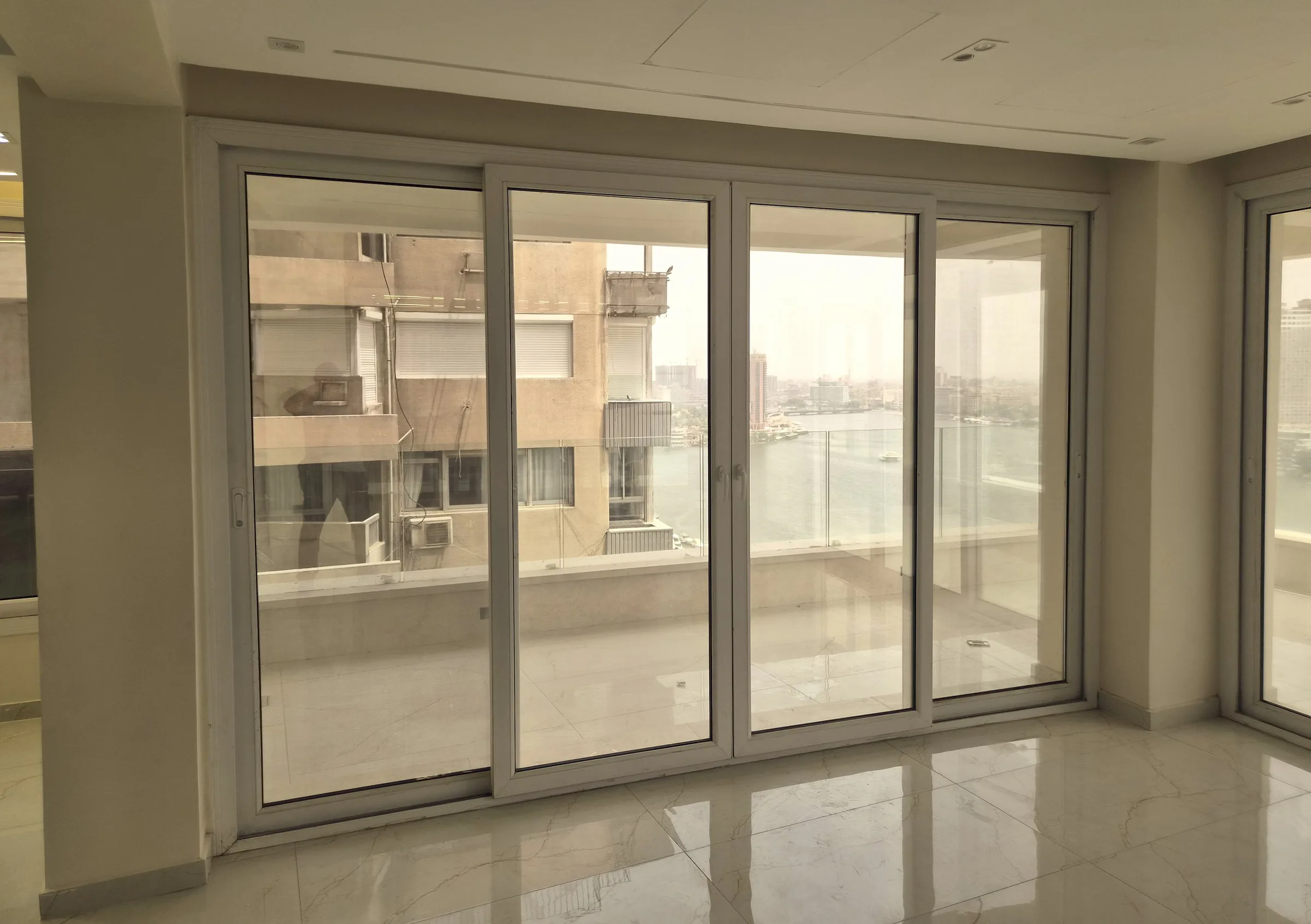 White uPVC sliding doors opening onto a balcony above the Nile