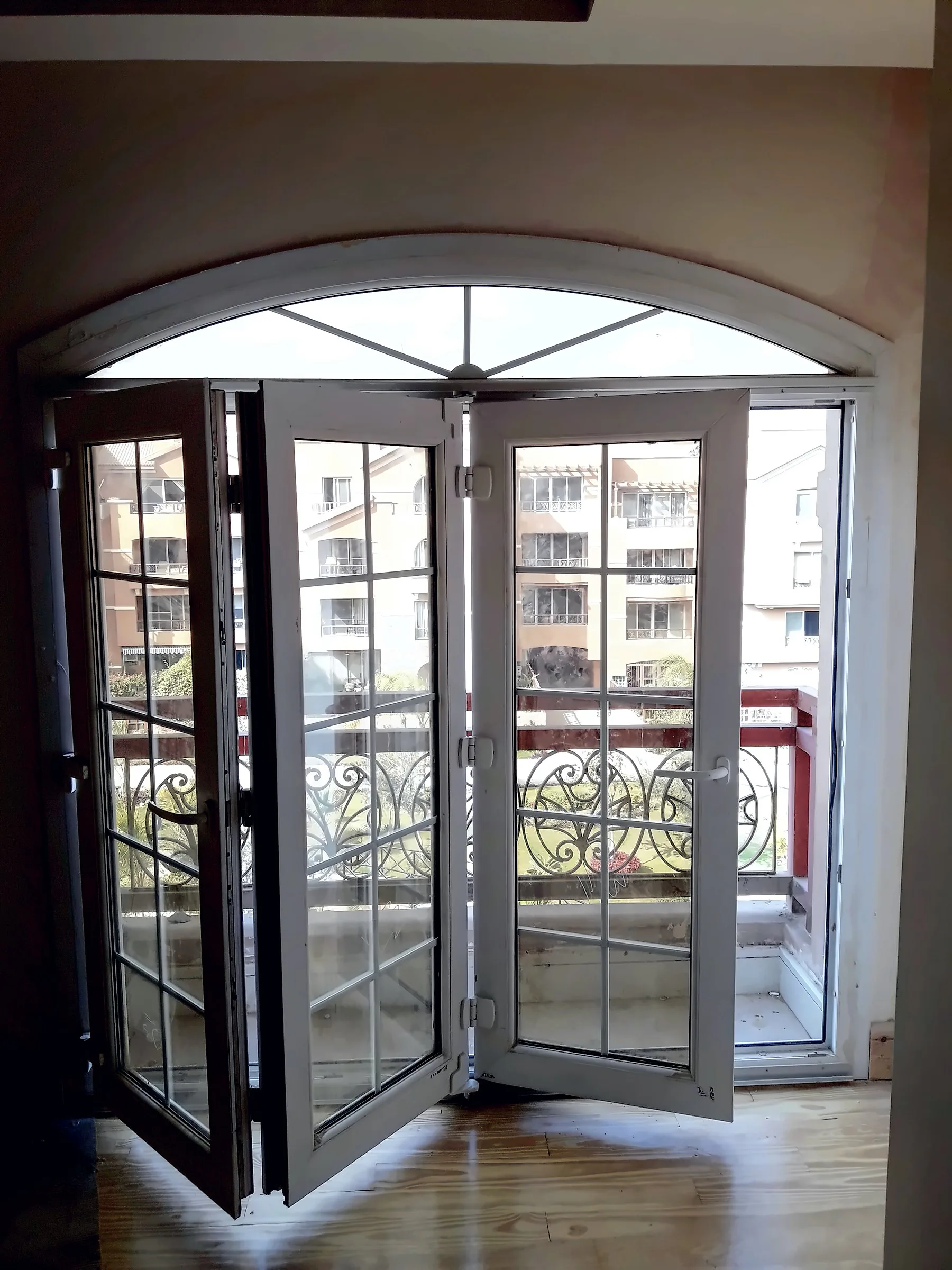 Arched doors folded back to open the room onto the balcony